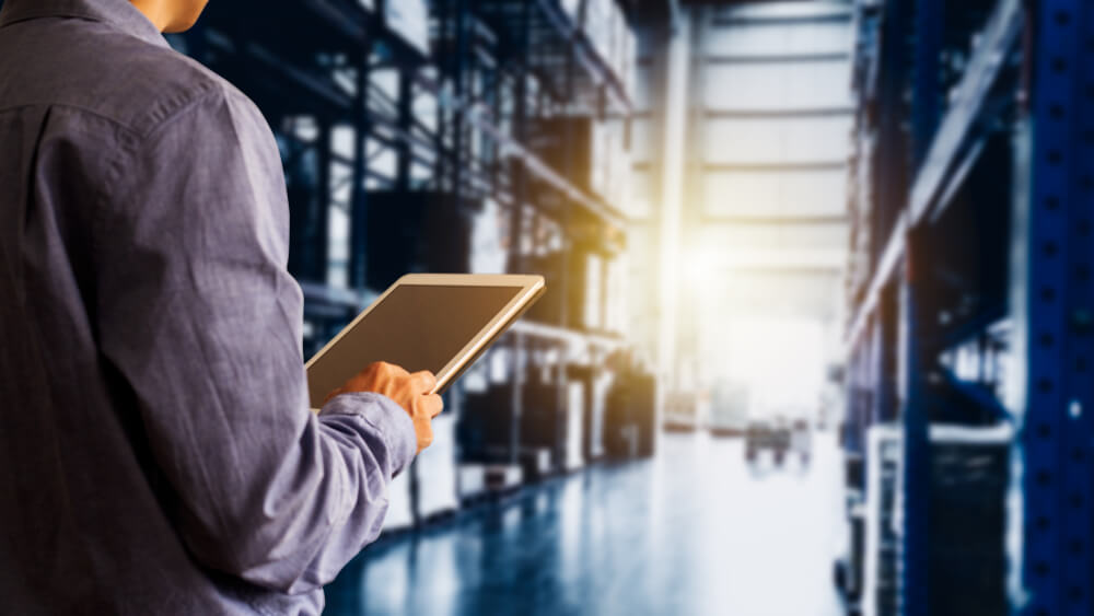 A warehouse worker using an AI solution as part of their supply chain management