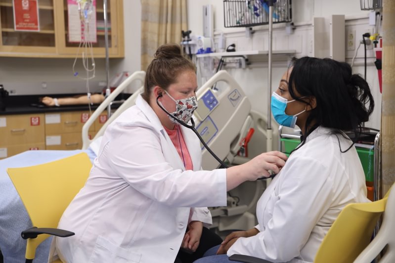 ABSN student Sarah Oney performing an exercise on a fellow student during their on-campus residency