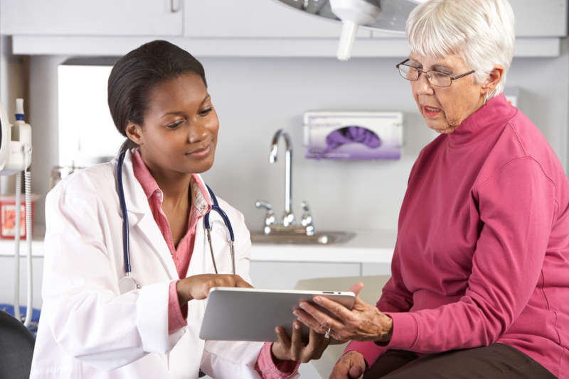 A public health nurse practitioner working with an elderly woman in her community