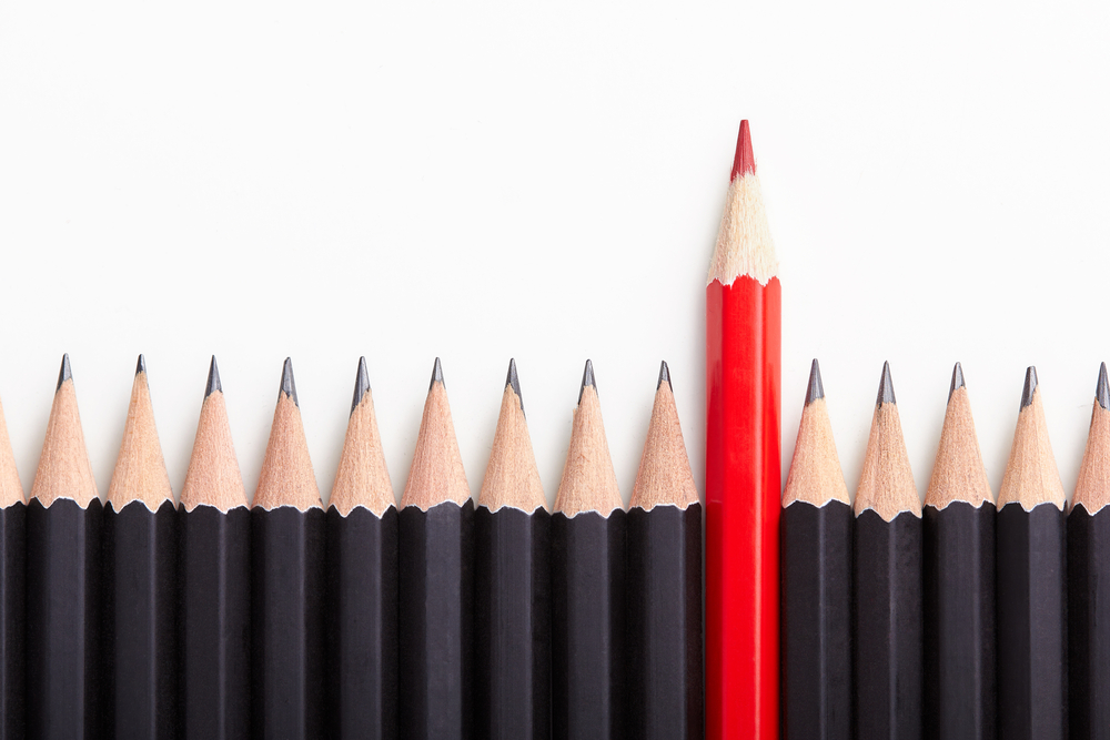 A colored pencil standing out among other pencils, representing the much lauded role of the educational leader