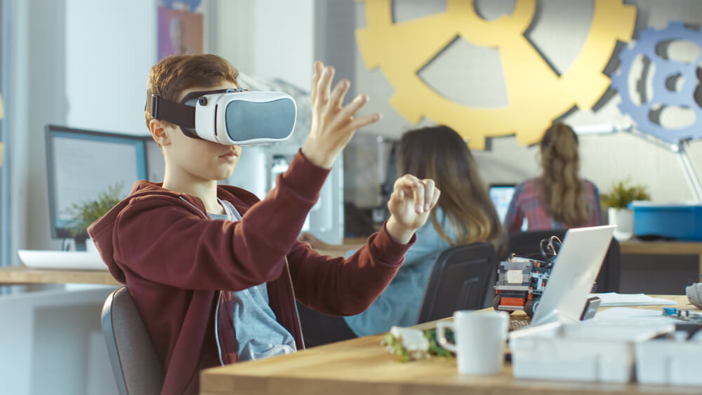 A student in a classroom uses a VR headset.