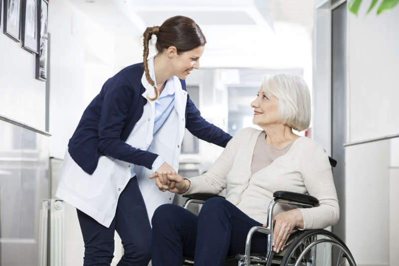 A long term care nurse greeting her patient