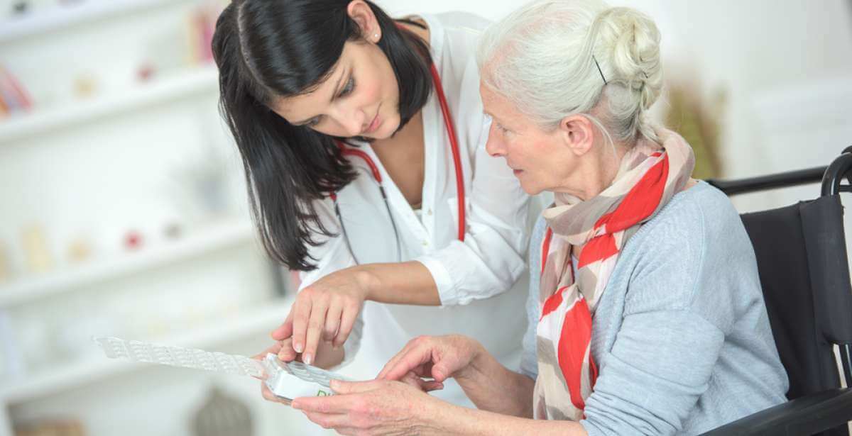 An APRN explaining a diagnosis to an elderly patient