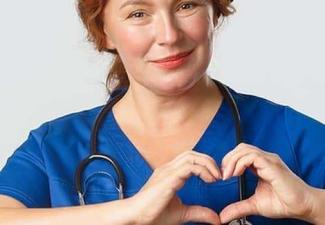 A nurse making heart hands